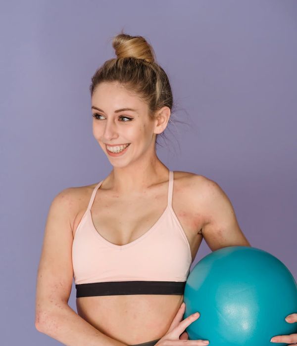 A woman in activewear smiling, feeling energetic and positive after a workout.